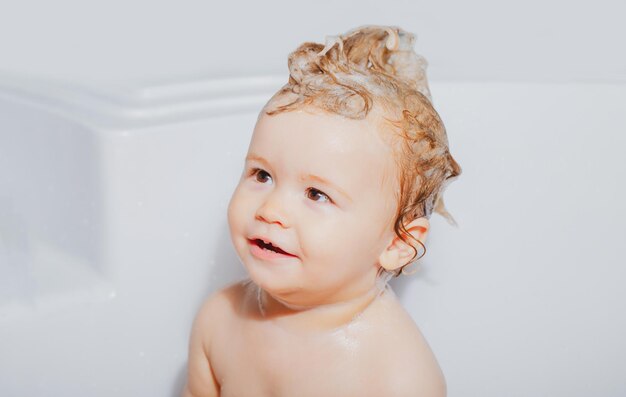 Criança tomando banho bebê feliz tomando banho brincando com bolhas de espuma criança em uma banheira sorrindo k