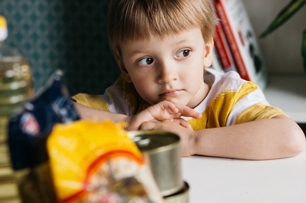 Foto criança triste com comida doada. conceito de entrega de comida.