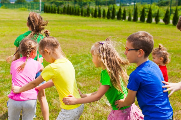 Jogos ativos para crianças em idade escolar e pré-escolares no ar. agachar  e pular. jogo ao ar livre para grupo de crianças.