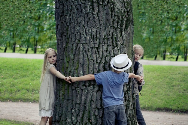 Crianças abraçando a árvore proteção ambiental natureza ao ar livre conservação ao ar livre