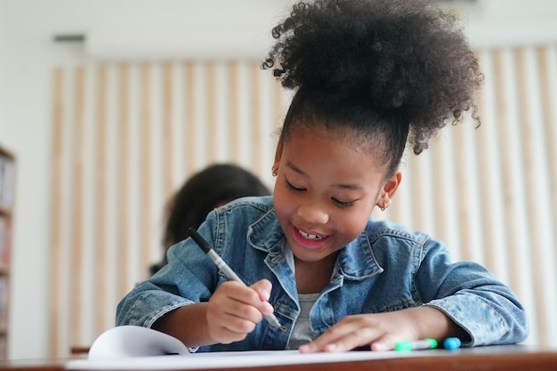 Crianças africanas desenhando e fazendo lição de casa na sala de aula jovem feliz estudo engraçado na escola