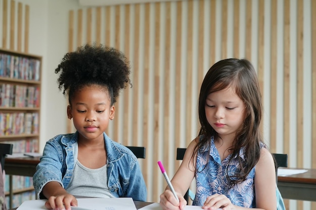 Crianças africanas desenhando e fazendo lição de casa na sala de aula jovem feliz estudo engraçado na escola