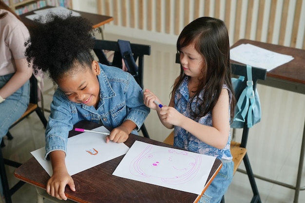 Crianças africanas desenhando e fazendo lição de casa na sala de aula jovem feliz estudo engraçado na escola