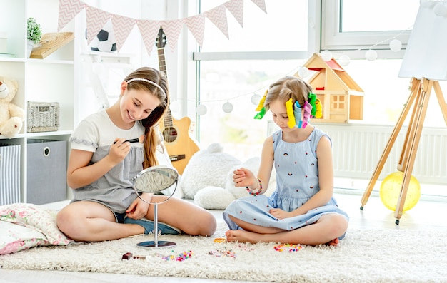 Crianças alegres meninas brincando com maquiagem