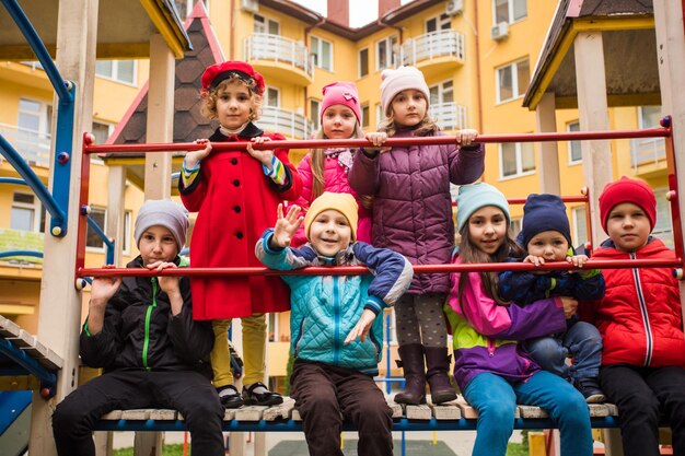 Crianças alegres no playground ao ar livre no início da primavera