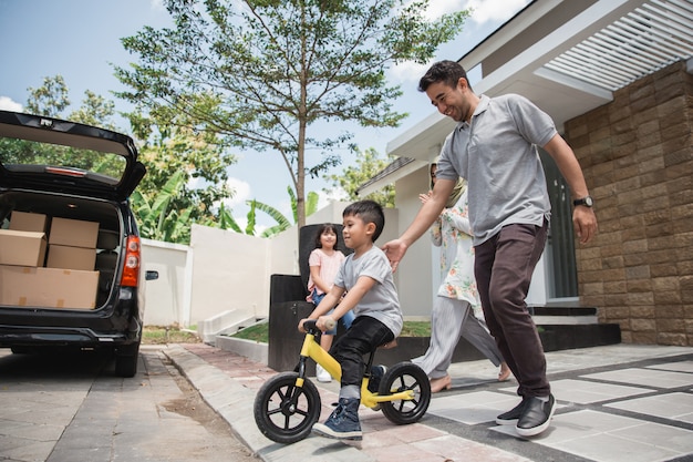 Crianças andam de bicicleta por seu pai