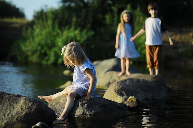 Crianças andam no verão na natureza Criança em uma manhã ensolarada de primavera no parque Viajando com crianças