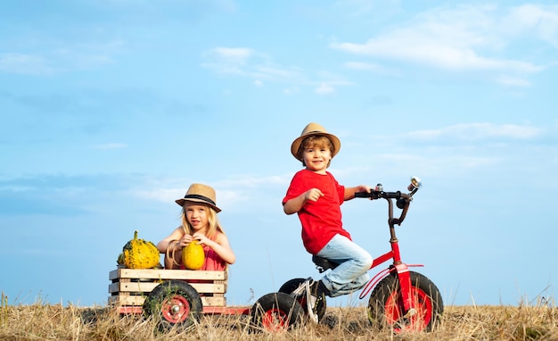 Crianças andando de bicicleta crianças prontas para trabalhar na fazenda infância no campo verão no campo vida ecológica infância despreocupada pequenos agricultores felizes se divertindo no campo