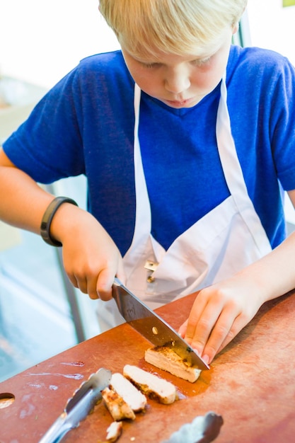 Crianças aprendendo a cozinhar em uma aula de culinária.