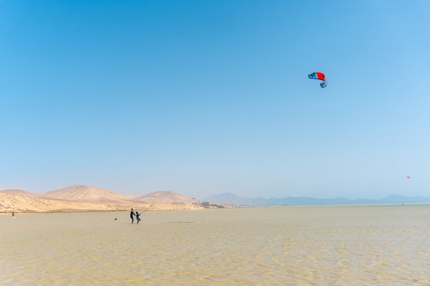 Crianças aprendendo kitesurf ou sky surf na praia de Sotavento, no sul de Fuerteventura, nas Ilhas Canárias. Espanha