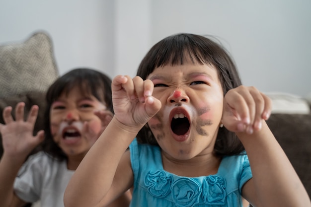 Crianças asiáticas, com os rostos pintados