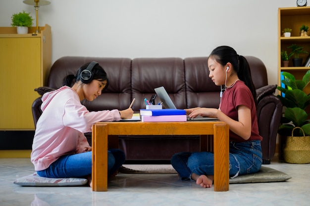 Crianças asiáticas estudam sozinhas com e-learning em casa. Educação online, auto-estudo e conceito de educação escolar em casa.