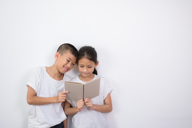 Foto crianças asiáticas lendo um livro juntos