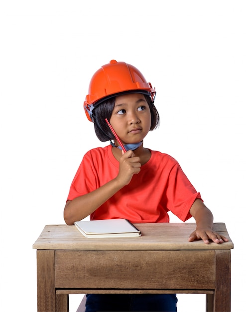 Crianças asiáticas que vestem o capacete de segurança e pensamento isolado no fundo branco. Crianças e conceito de educação