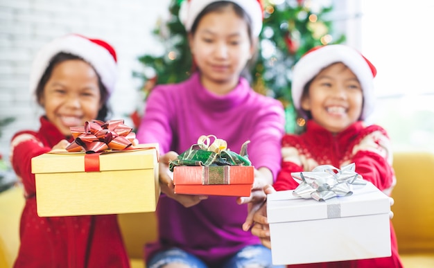 Crianças asiáticas segurando caixas de presente bonita e dando na celebração de natal