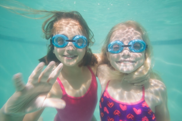 Crianças bonitas posando debaixo d&#39;água na piscina