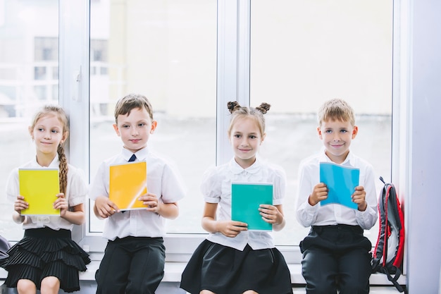 Crianças bonitas são alunos juntos em uma sala de aula na escola recebem educação felizes