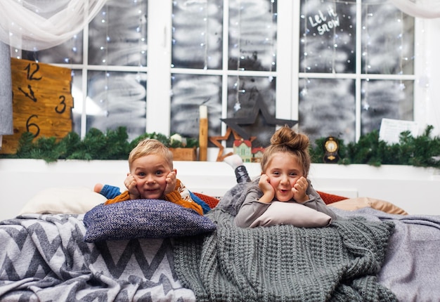 Crianças bonitinhas menino e menina em casa esperando o papai noel