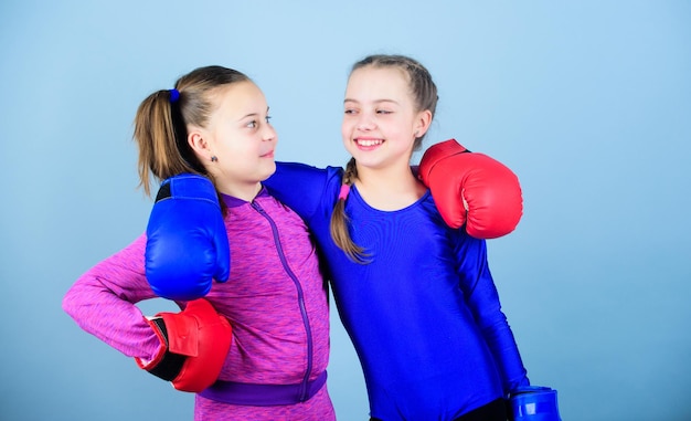 Crianças boxeadoras em luvas de boxe Adolescentes confiantes Boxeadoras femininas O boxe fornece disciplina rigorosa Competidores no ringue e amigos na vida Garotas boxeadoras fofas em fundo azul Garotas no esporte de boxe