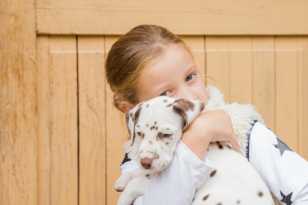 Crianças brincam com cachorrinhos fofos Crianças e cachorrinhos brincando no jardim ensolarado de verão Menina segurando cachorrinhos Criança com cachorro de estimação Família e animais de estimação no gramado do parque Amizade de crianças e animais