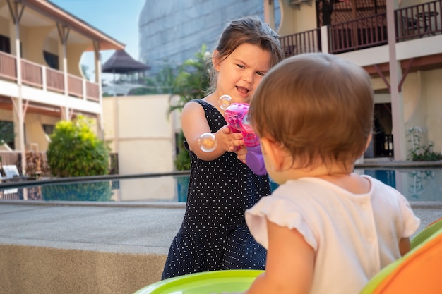 Crianças brincam no quintal com bolhas de sabão