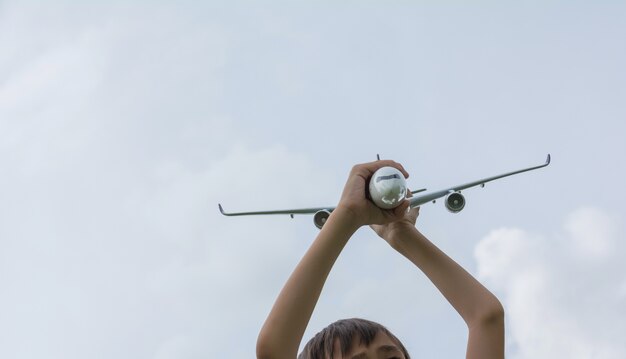 Foto crianças brincando com o avião de brinquedo no tempo do dia