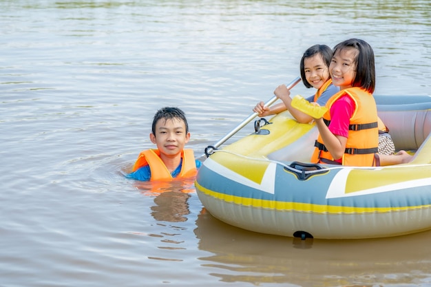 Crianças brincando e barco a remo no rio da fazenda orgânica na zona rural