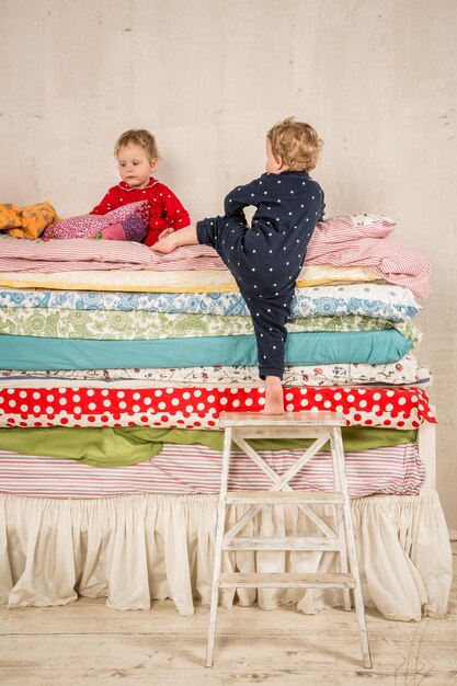 Crianças brincando na cama - a princesa e a ervilha.