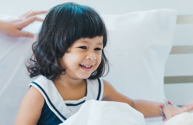 Crianças brincando na cama feliz.