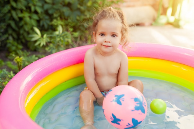 Crianças brincando na piscina de bebê inflável.