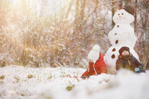 Crianças brincando no parque de inverno com neve