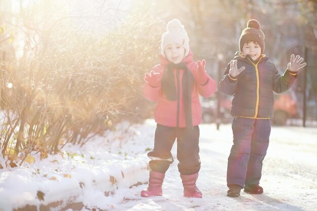 Crianças brincando no parque de inverno com neve