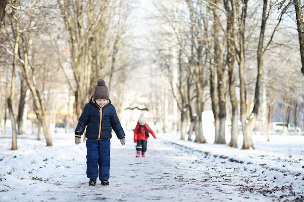 Crianças brincando no parque de inverno com neve