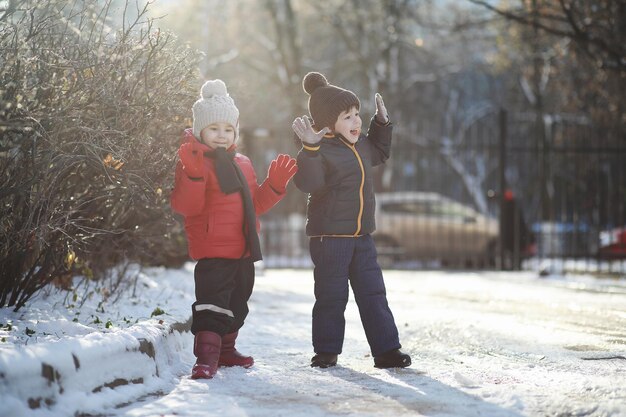 Crianças brincando no parque de inverno com neve