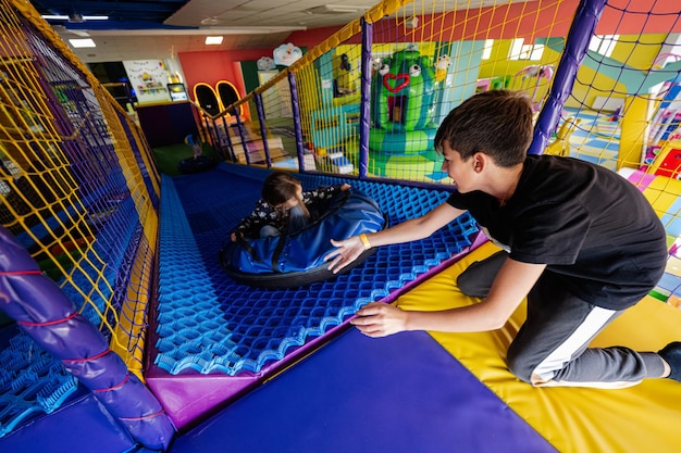 Crianças brincando no playground indoor play center em tubos