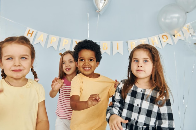 Crianças celebrando a festa de aniversário dentro de casa se divertem juntos