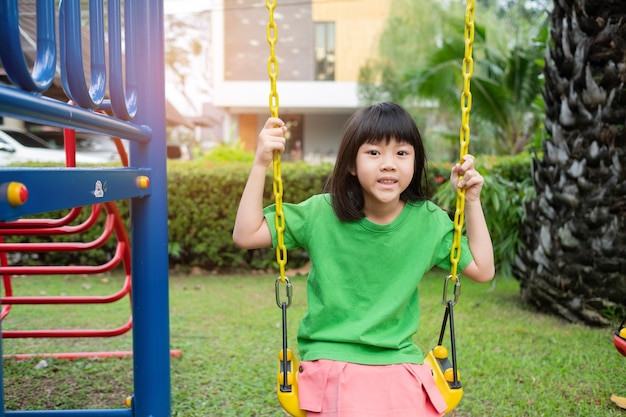 Crianças chinesas brincando de balanço se divertem com playground