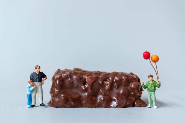 Crianças com barras de chocolate em pé sobre fundo cinza Conceito do Dia Mundial do Chocolate