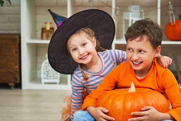 Crianças com fantasias de halloween se divertem em um quarto decorado