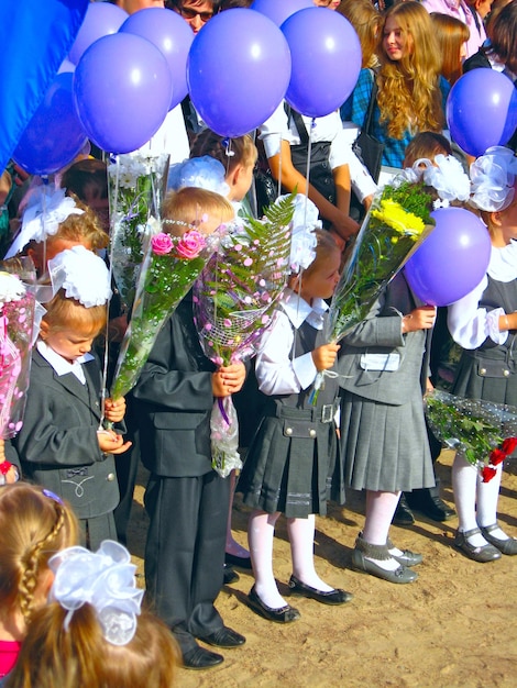 Crianças com flores e balões em um feriado de 1o de setembro
