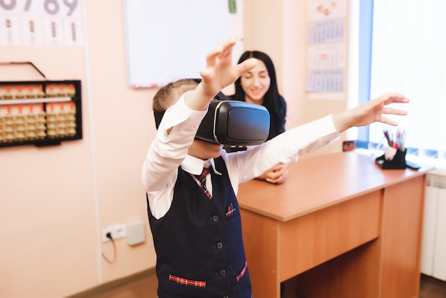 Foto crianças com óculos de realidade virtual estão na secretaria da escola