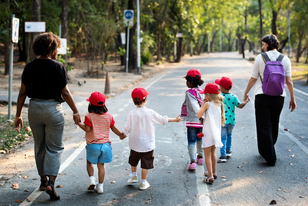 Crianças com professor caminhando juntos viagem de campo