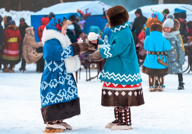 Crianças com roupas nacionais comem lã de açúcar. Dia de feriado das renas dos povos do norte Khanty e Mansi.