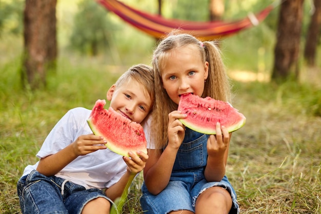 Crianças comendo melancia no parque