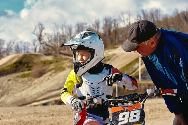 Foto crianças competindo em competições juniores de motobike em motocicleta o treinador dá instruções para seu jovem piloto