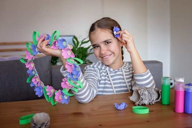 Crianças criam guirlanda de flores de páscoa em tons pastéis usando um estilo de vida de desperdício zero de trilha de ovo reciclado