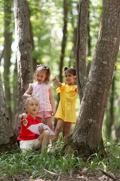 Foto crianças curiosas participando de uma caça ao tesouro na floresta