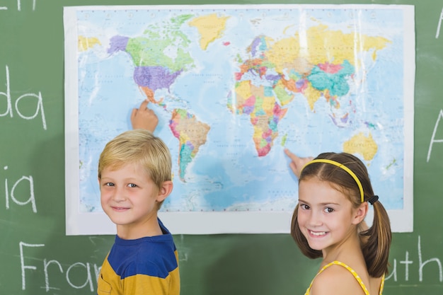 Crianças da escola, apontando para o mapa na sala de aula