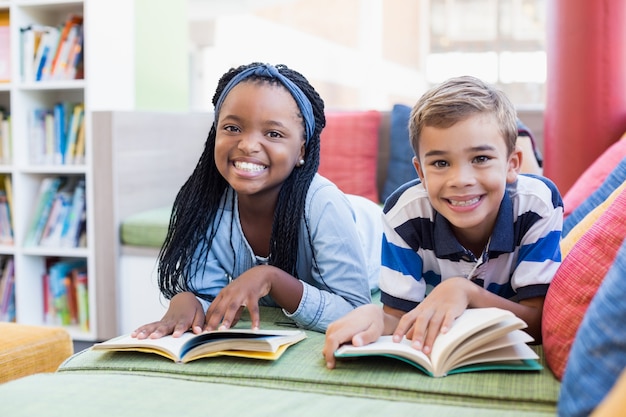 Foto crianças da escola deitado no sofá e livro de leitura