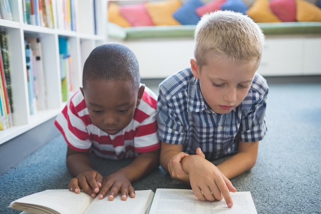 Crianças da escola lendo livro na biblioteca